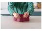 Une personne assemble un moule de cuisson en silicone rouge sur un comptoir de cuisine.