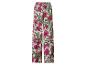 Damesbroek met wijde pijpen en tropisch patroon van roze hibiscus en groene bladeren.