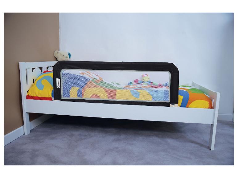 Lit enfant blanc avec barrière de lit noire Safety 1st et literie colorée.