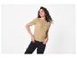 Vrouw in een beige top met korte mouwen en zwarte jeans, met armbanden en een ring.