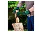 Een persoon met groene handschoenen splijt hout met een Parkside bijl.