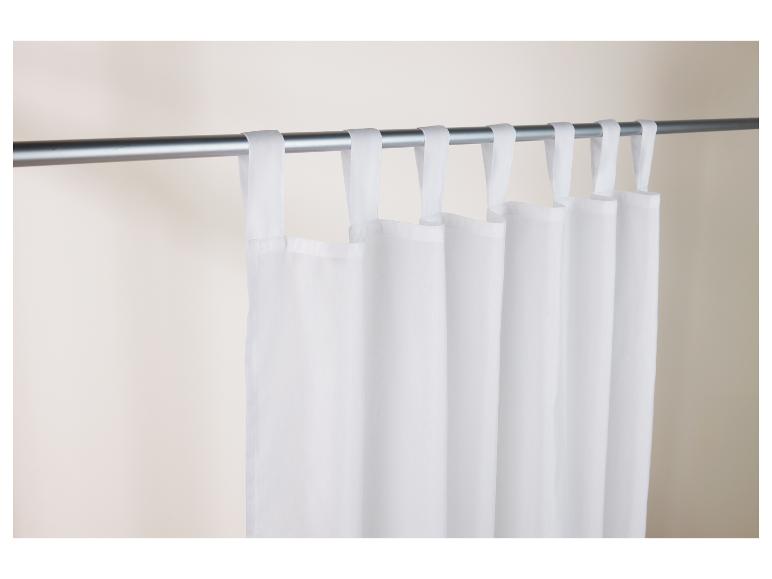 Witte gordijnen met plooien hangen aan een zilveren roede.