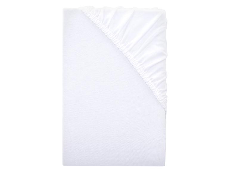 Drap-housse blanc avec coins élastiques.