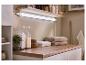 Aménagement de salle de bain avec étagère, éclairage, serviettes et bouteilles de rangement.