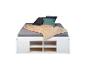 Lit blanc avec rangement, literie grise, couverture beige et oreillers.