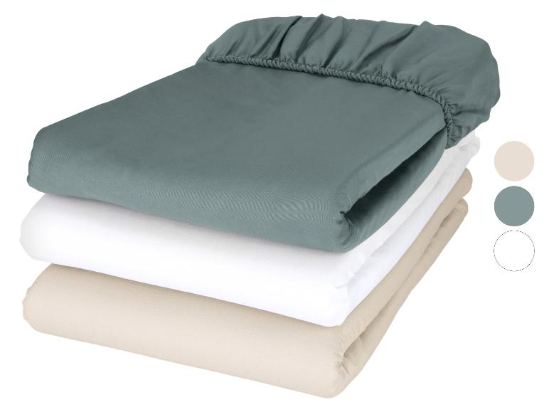 Stapel hoeslakens in teal, wit en beige met kleurstalen.