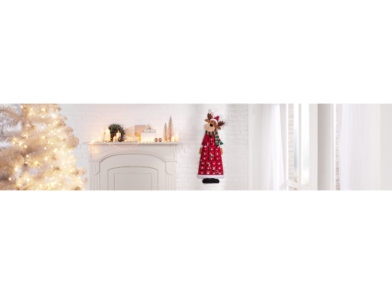 Verlichte witte kerstboom, versierde open haard en rendier adventskalender.