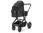 Een zwarte kinderwagen met een wieg en een boodschappenmand.