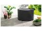 Une housse de protection noire pour une table de jardin ronde.