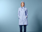 Une femme dans un imperméable bleu avec une capuche.