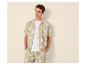 Man in overhemd en korte broek met palmbladeren, casual zomerstijl.