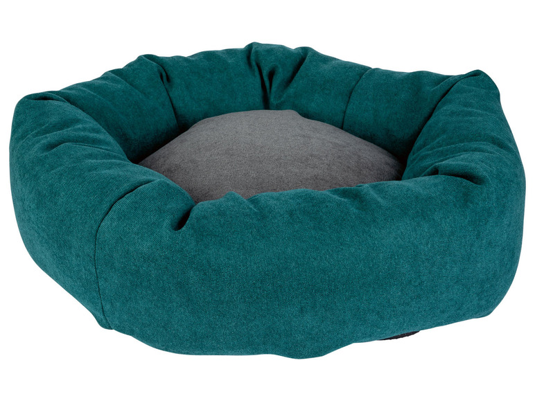 Een turquoise hondenmand met een grijs kussen.