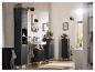 Salle de bain moderne avec meubles noirs, lavabo blanc et plantes vertes.