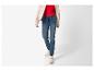 Femme en veste beige, haut rouge et jean jogger avec baskets.