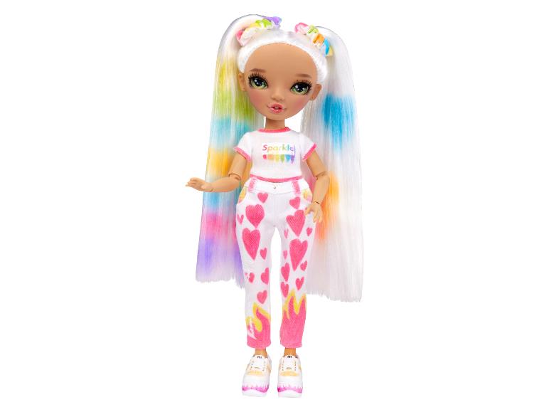 Une poupée avec de longs cheveux blancs avec des rayures arc-en-ciel, un t-shirt blanc avec l'inscription 'Sparkle' et un pantalon à cœurs roses.