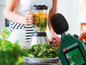 Een vrouw maakt een smoothie met een blender, terwijl een Parkside geluidsmeter de decibellen meet.