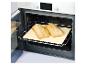 Twee versgebakken broden op een pizzasteen in een open oven.