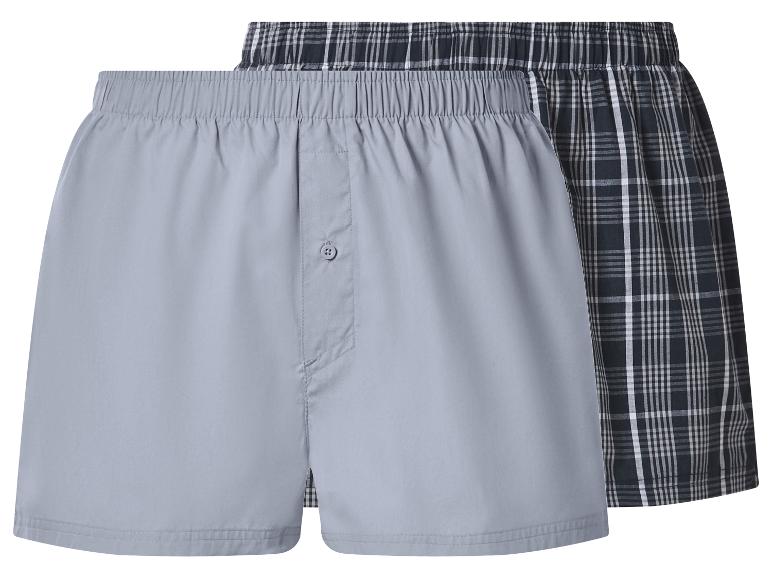 Twee herenboxershorts: één grijs, één zwart geruit.