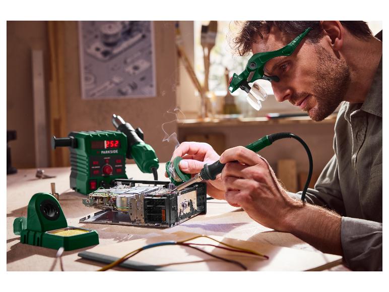 Man soldeert elektronica met Parkside-apparatuur, inclusief een soldeerstation en vergrootbril.