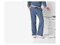 Vrouw in een blauwe loungewear set met witte sneakers, vasthoudend aan een metalen stoel.