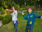 Twee kinderen spelen buiten met een speelgoedraket en een vliegtuig.