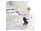 Un enfant assis à une table et une chaise Peppa Pig, prêt à jouer.