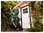 Vrouw gebruikt de PARKSIDE® accu-bladzuiger en -blazer in de tuin.