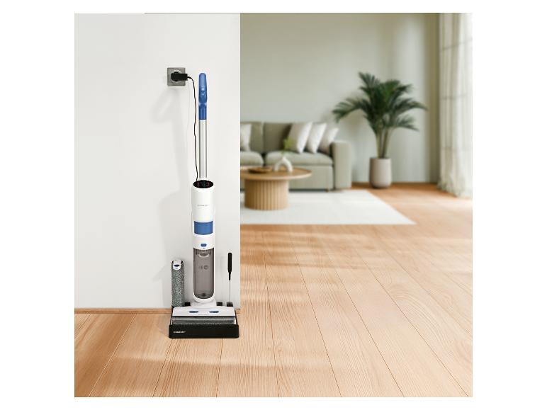 Aspirateur et lave-sol 2 en 1 sans fil en charge dans un salon.