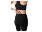 Femme en brassière de sport noire et legging avec téléphone dans la poche