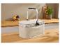 Beige picknickmand met aluminium handvat op een houten aanrecht.