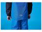 Kind in blauwe en zwarte ski-jas en -broek met berglogo op de rug.