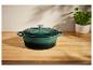 Groene gietijzeren pan op een houten tafel.
