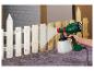 Persoon spuit een houten hek wit met een Parkside verfspuit.