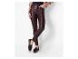 Vrouw draagt donkerbruine skinny jeans en zwarte loafers met kwastjes.