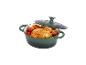 Un poulet rôti avec des légumes dans une cocotte en fonte verte.