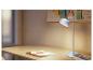 Bureaulamp met een notitieboekje en potloden op een houten bureau.