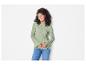 Een vrouw draagt een lichtgroene trui met pofmouwen en blauwe jeans.