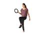 Femme en leggings noirs et haut violet, tenant un anneau d'exercice noir, avec une jambe levée.