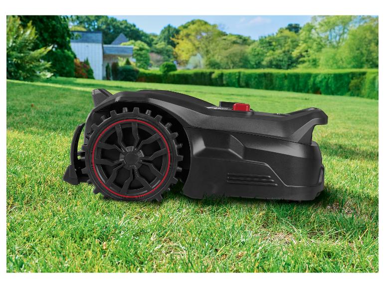 Zwarte robotmaaier met rode accenten op een groen gazon voor een huis.
