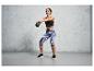 Een vrouw in trainingskleding met een kettlebell.