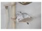 Chat argenté allongé sur un lit beige sur un arbre à chat.