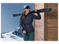 Een vrouw in een blauwe ski-jas met een ski op haar schouder