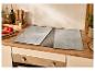 Protections en verre pour table de cuisson, style béton, sur un plan de travail de cuisine moderne en bois.