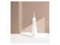 Witte Cien Beauty monddouche op een oplaadstation, met beige achtergrond