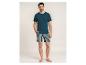Homme en t-shirt bleu foncé et short rayé.