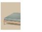 Een lichtgroen matras op een houten bedframe tegen een beige achtergrond.