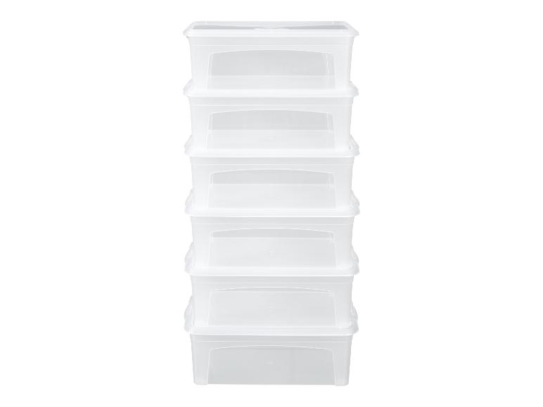 Zes stapelbare, transparante opbergdozen.
