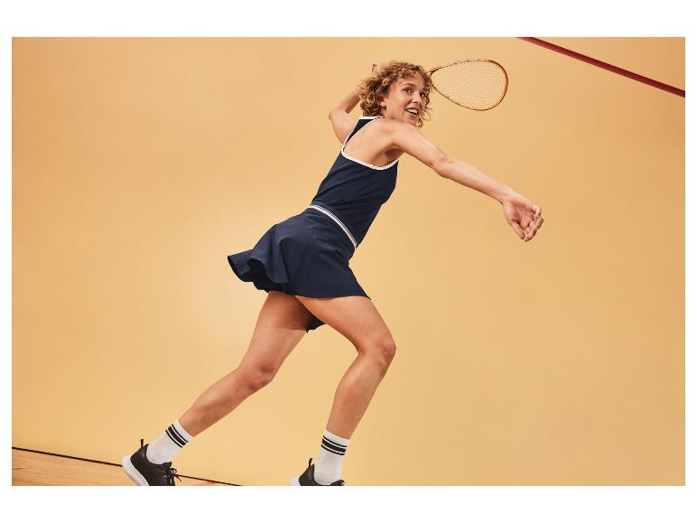 Vrouw speelt squash in bijpassende rok en top.