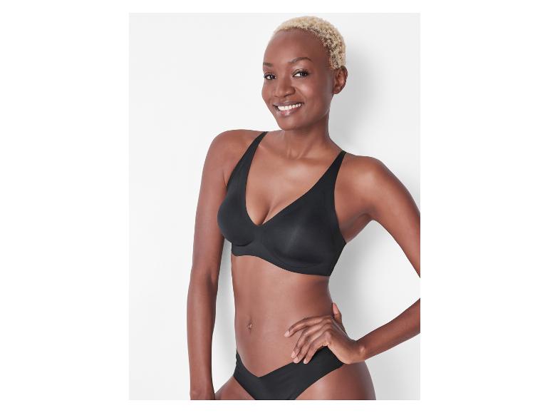 Femme souriante aux cheveux blonds courts, portant un soutien-gorge et une culotte noirs.