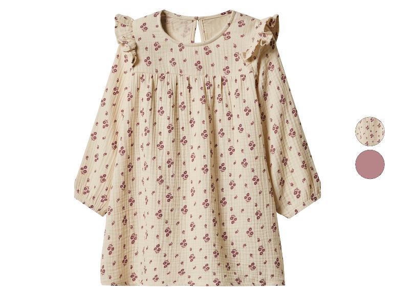 Beige kinderjurk met lange mouwen en paars bloemenpatroon.